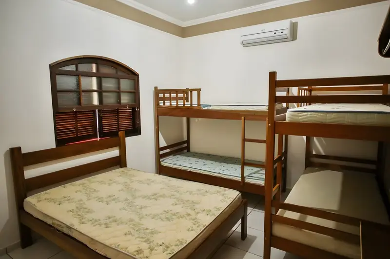 Suíte com cama de casal, beliches de madeira e ar-condicionado